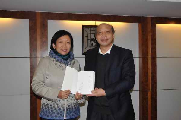 报告会前，校党委书记王枬和蒋述卓校友互赠礼物（赵晋凯 摄）