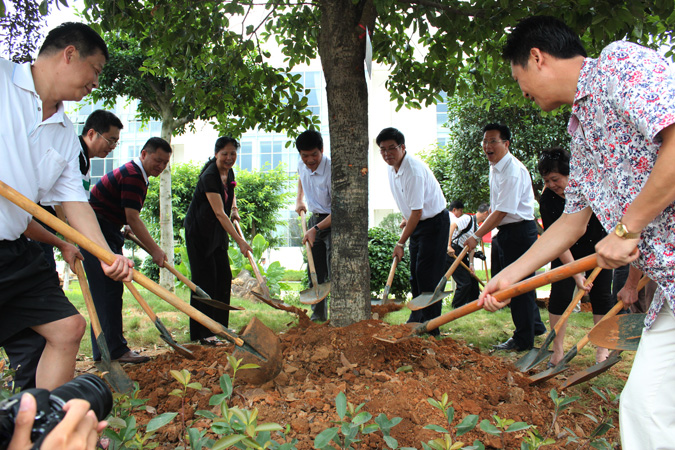 校友与学校领导一起为体育学院门前的树培土