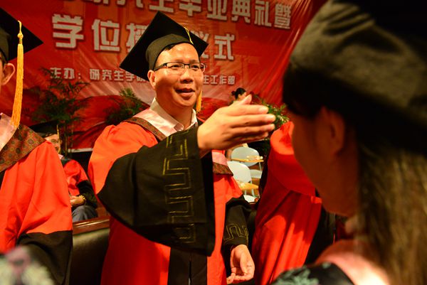 副校长覃卫国为毕业生拨流苏、颁发学位（大学生通讯社 陈园园 摄）